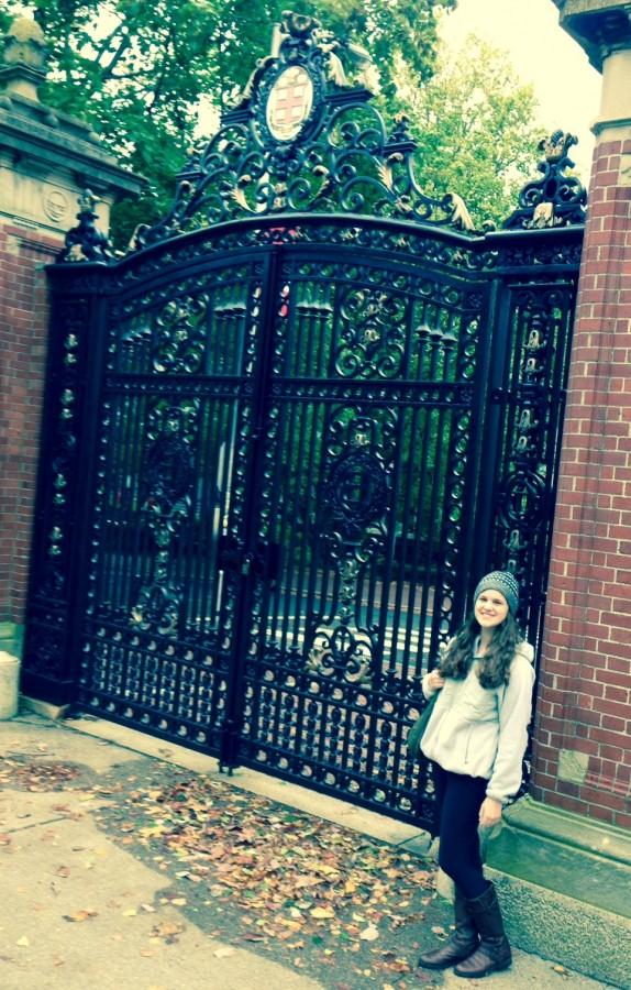 Kate Schneider stands in front of the gate at Brown University.