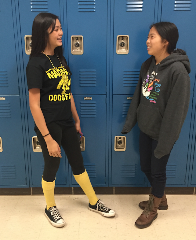 Two students happily converse with each other in the hallway.