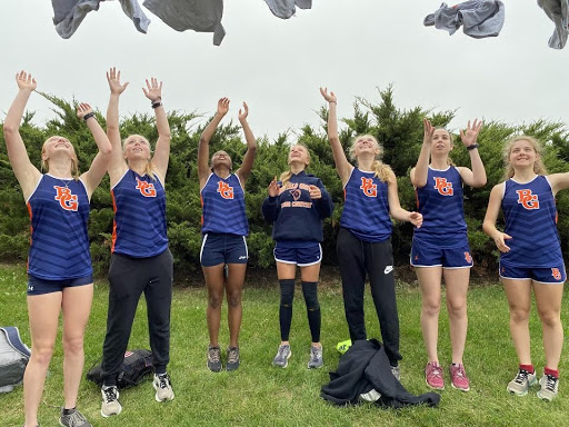 Members of the varsity girls’ cross country team celebrate their victory.