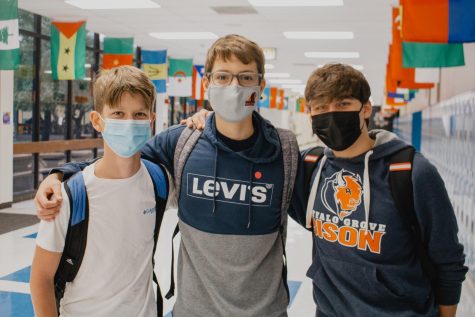 Not totally back to normal: a few sophomores pose for a picture in the hallway wearing masks per state mandate.